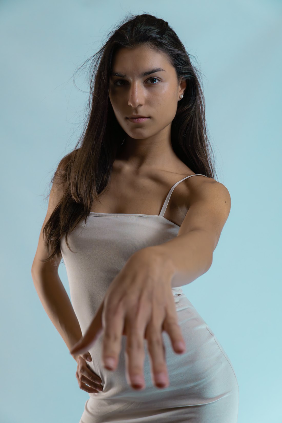 Studio-Portrait einer Frau im weißen Kleid vor hellblauem Hintergrund – PromoFlicks